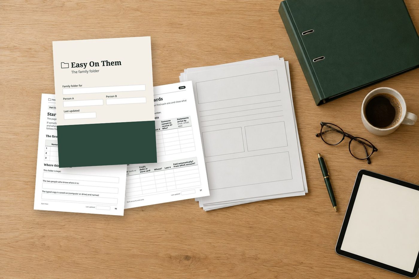 Printed pages of the Easy On Them folder on a kitchen table, with a binder, a pen and reading glasses